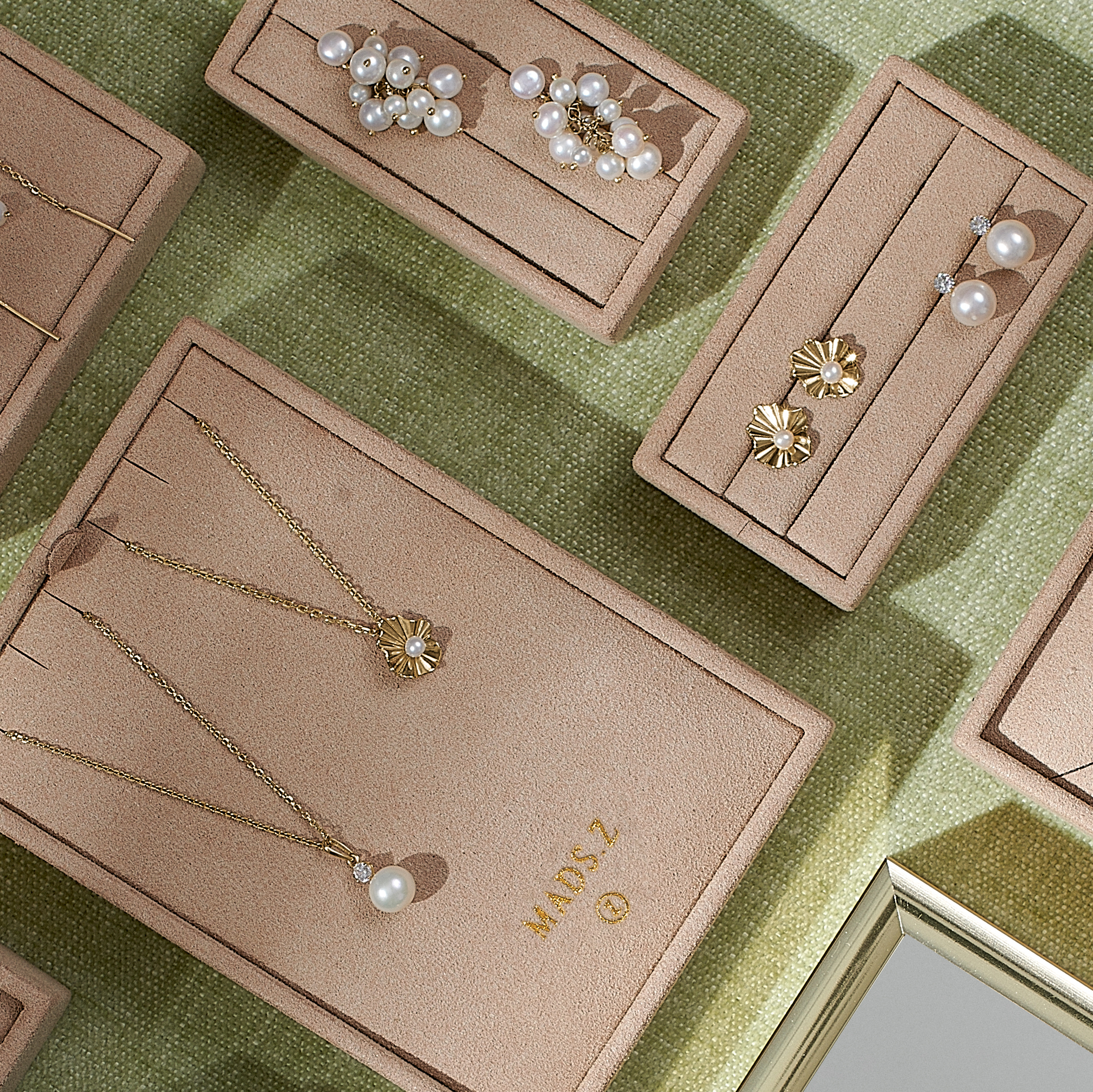 Elegant sortiment af Mads Z smykker, fremviser forskellige ringe, halskæder og armbånd i udsøgt design.
